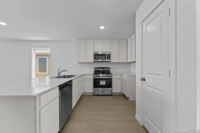 a kitchen with granite countertop a refrigerator and a stove top oven