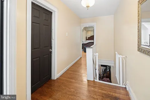 a view of a hallway with wooden floor and staircase