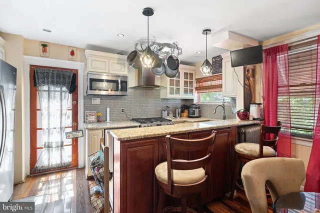 a kitchen with stainless steel appliances granite countertop a sink and a refrigerator