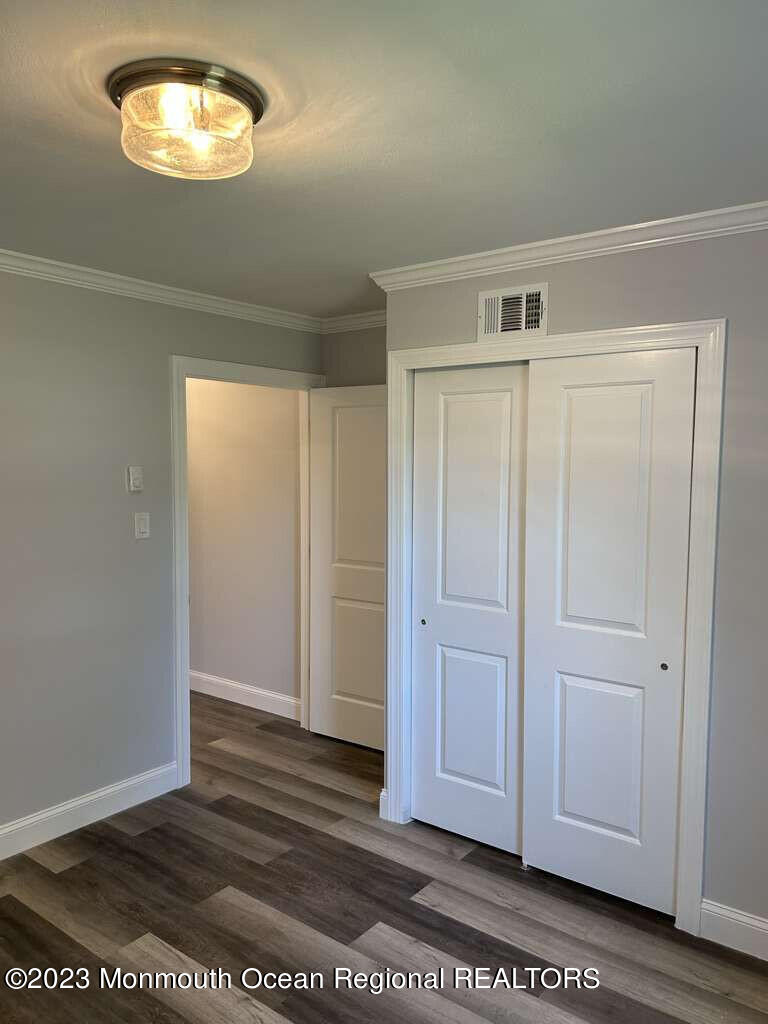 48 East Piazza Tasso Freehold, NJ 07728 - Photo 2 of 21 an empty room with wooden floor and cabinet