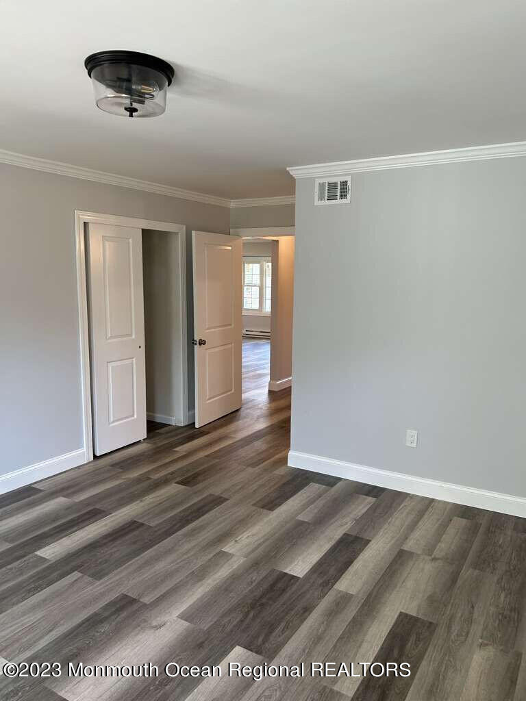 48 East Piazza Tasso Freehold, NJ 07728 - Photo 8 of 21 a view of an empty room with wooden floor and a window