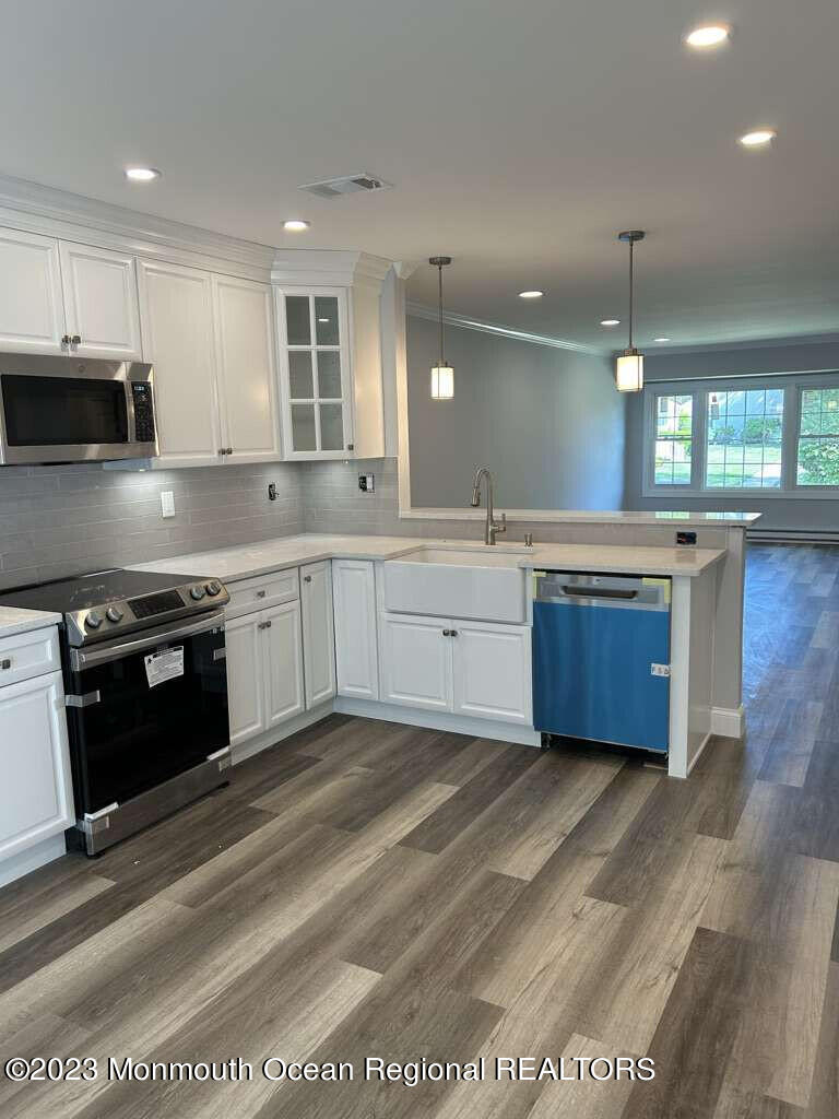48 East Piazza Tasso Freehold, NJ 07728 - Photo 10 of 21 a large kitchen with stainless steel appliances granite countertop a stove a sink and a microwave