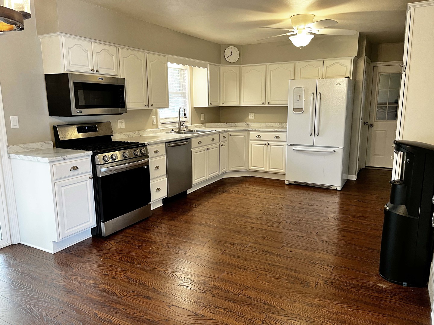2438 Erskine Road Joliet, IL 60433 - Photo 23 of 42 a kitchen with granite countertop a stove top oven a sink dishwasher and a refrigerator with wooden floor