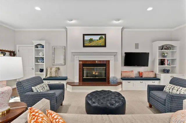 a living room with furniture a flat screen tv and a fireplace