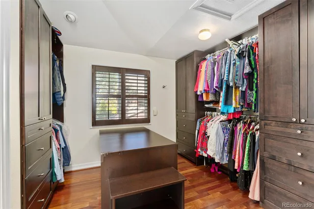 a view of walk in closet with clothes and shoes
