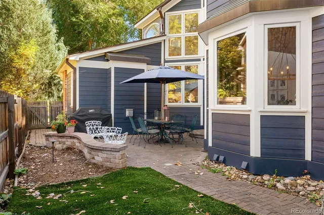 a view of a chair and table in backyard of the house
