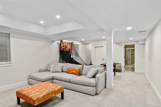 a living room with furniture and a gym with wooden floor