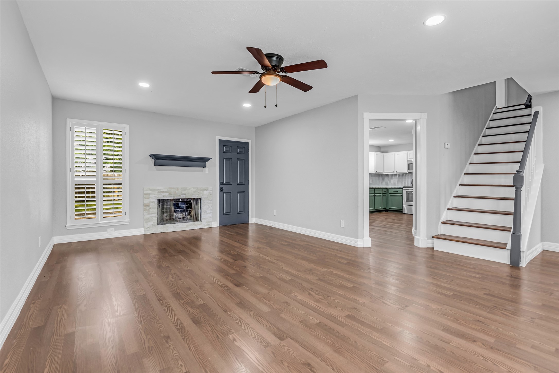4795 Slade Ben Lane Alvin, TX 77511 - Photo 4 of 25 an empty room with wooden floor a ceiling fan and windows