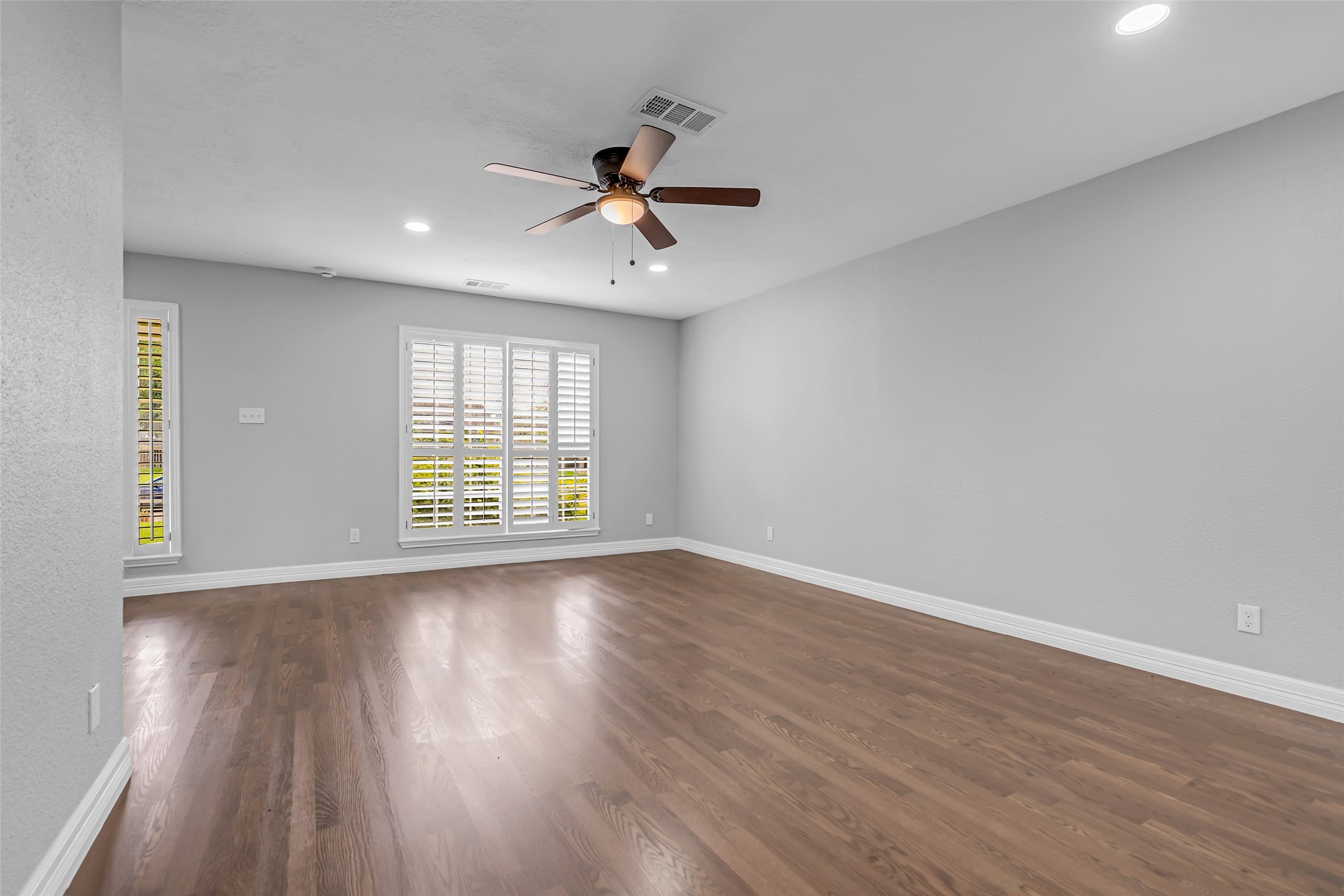 4795 Slade Ben Lane Alvin, TX 77511 - Photo 6 of 25 a view of an empty room with wooden floor and a window