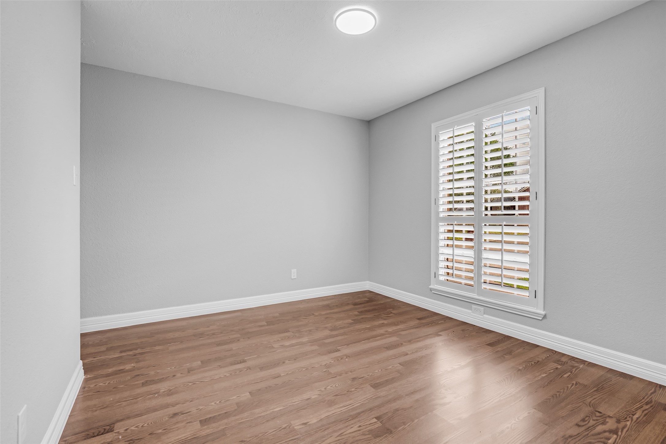 4795 Slade Ben Lane Alvin, TX 77511 - Photo 7 of 25 a view of an empty room with wooden floor and a window