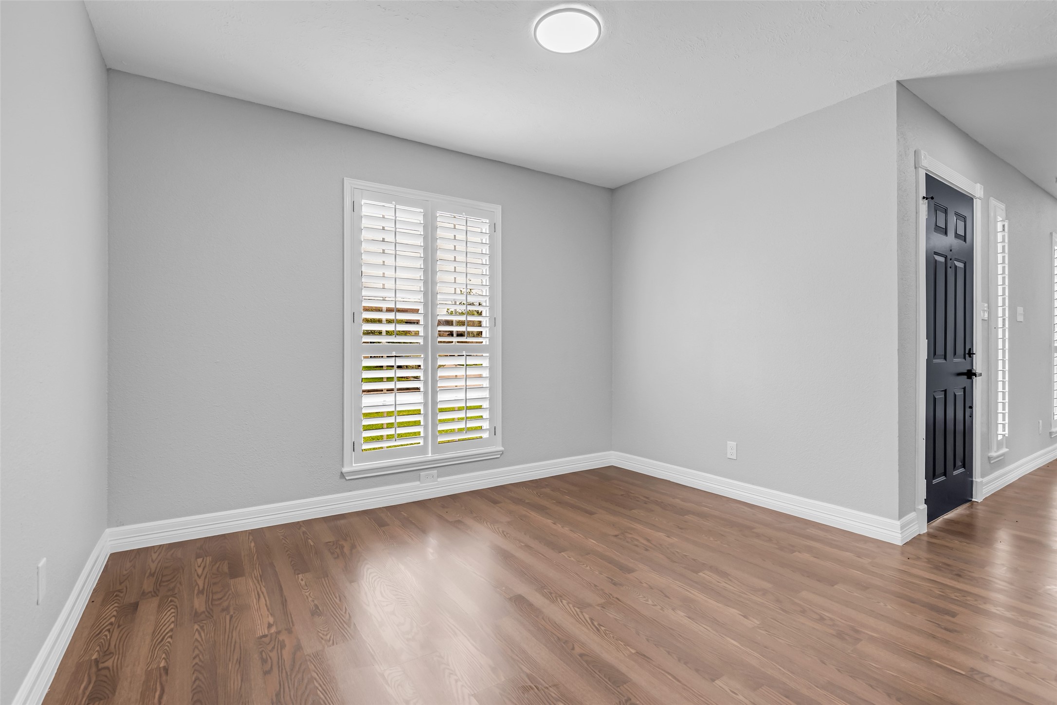 4795 Slade Ben Lane Alvin, TX 77511 - Photo 8 of 25 a view of an empty room with wooden floor and a window