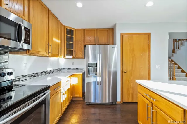 a kitchen with stainless steel appliances granite countertop a refrigerator and a stove top oven