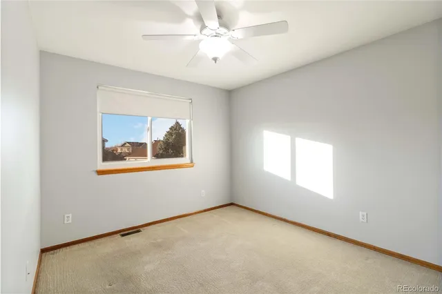 an empty room with a ceiling fan and a window