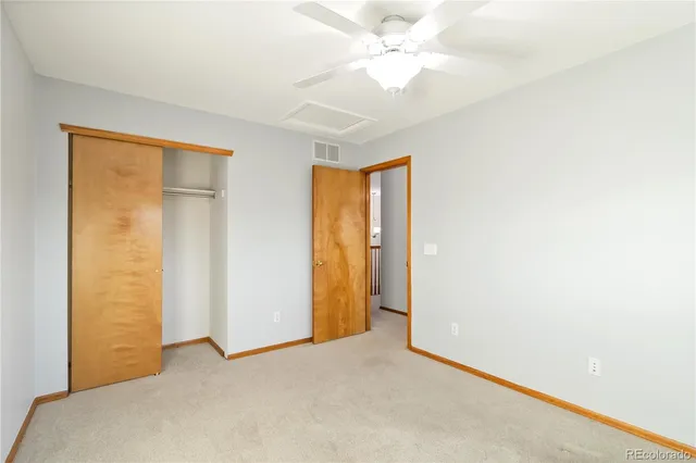 an empty room with a window and a ceiling fan