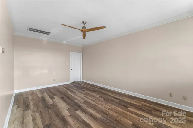 a view of room with wooden floor and ceiling fan
