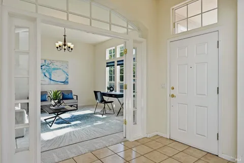 a living room with furniture a chandelier and wooden floor
