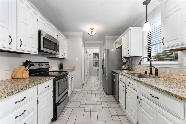 a kitchen with stainless steel appliances granite countertop grey cabinets a stove a sink and dishwasher