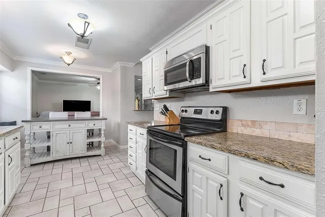 a kitchen with white cabinets and appliances
