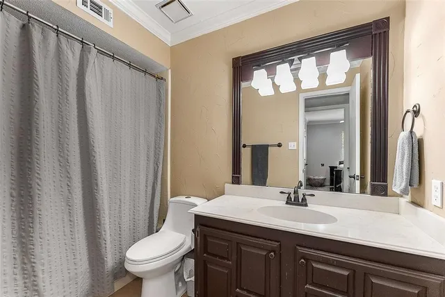 a bathroom with a granite countertop sink toilet and mirror
