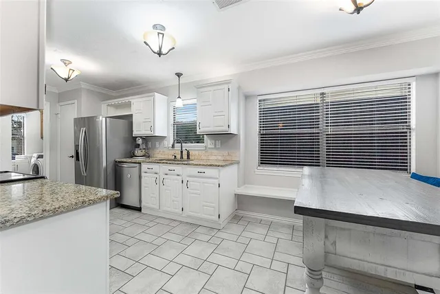 a kitchen with stainless steel appliances granite countertop a sink stove and cabinets