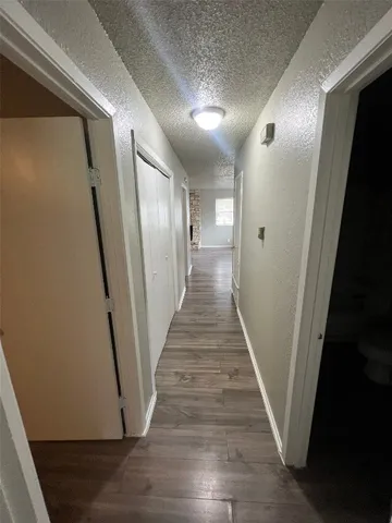 a view of a hallway with wooden floor and staircase
