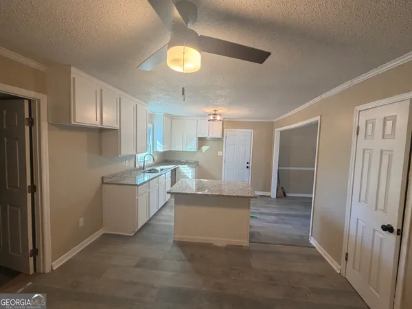 a kitchen with white cabinets and refrigerator