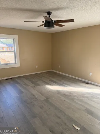 an empty room with a ceiling fan and window