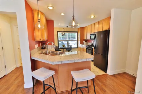 a kitchen with stainless steel appliances a dining table chairs and refrigerator