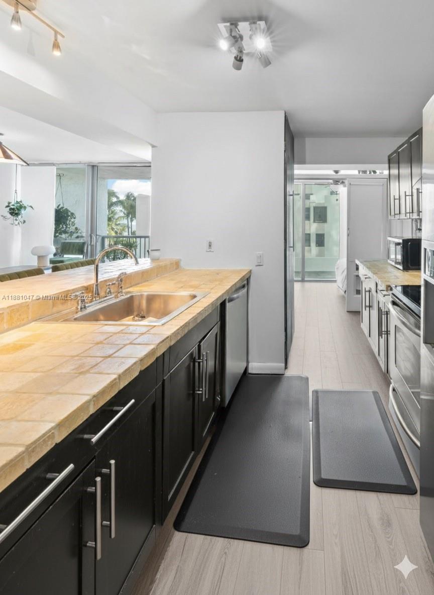 2655 Collins Avenue, Unit 510 Miami Beach, FL 33140 - Photo 11 of 23 a large kitchen with a wooden floor and cabinets