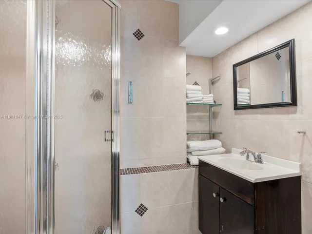 a bathroom with a sink mirror and a shower