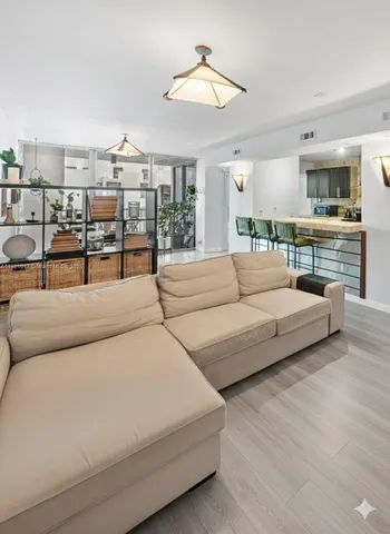 a living room with furniture and a chandelier