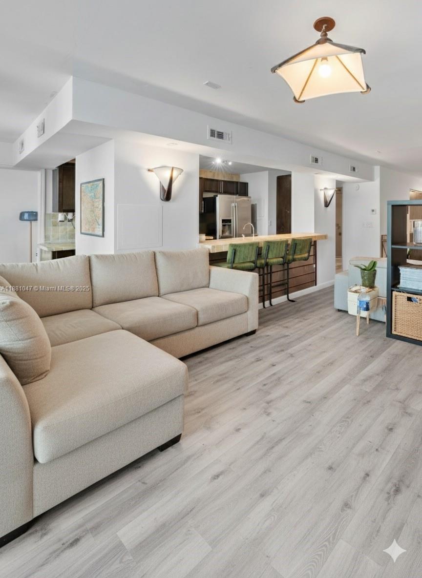 2655 Collins Avenue, Unit 510 Miami Beach, FL 33140 - Photo 6 of 23 a living room with furniture and a wooden floor