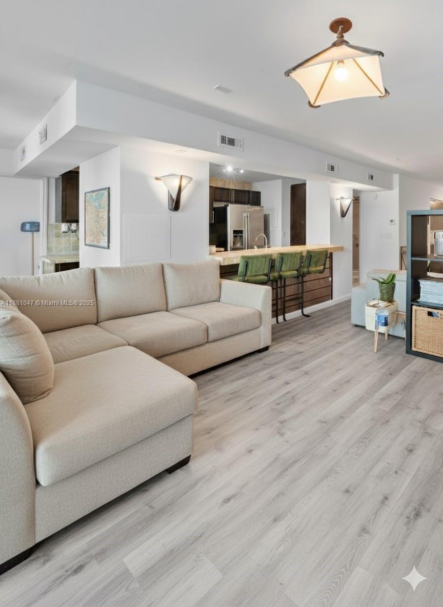 2655 Collins Avenue, Unit 510 Miami Beach, FL 33140 - Photo 8 of 23 a living room with furniture and a wooden floor