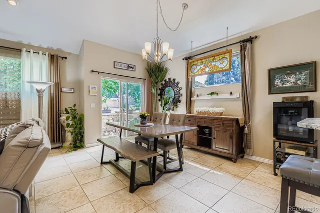 a dining room with furniture a chandelier and window