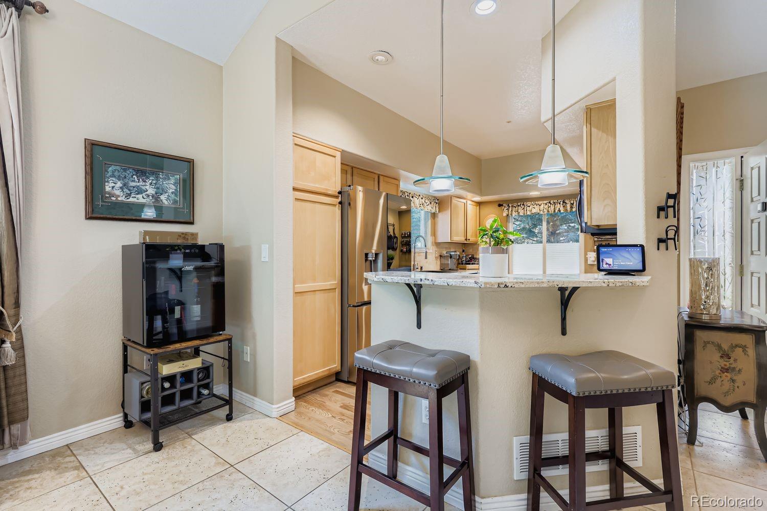 10752 Zuni Drive Denver, CO 80234 - Photo 7 of 27 a open kitchen with stainless steel appliances kitchen island granite countertop a refrigerator and a stove