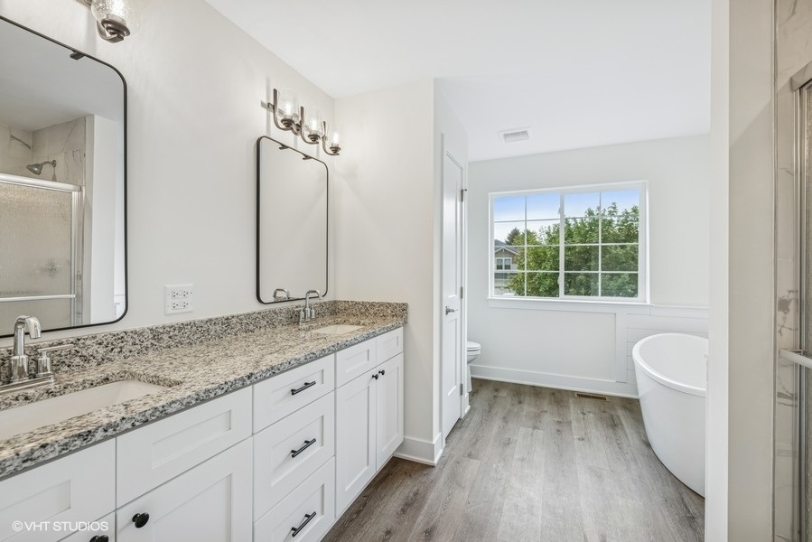 735 Fox Trail Terrace Cary, IL 60013 - Photo 15 of 21 a bathroom with a granite countertop sink a large mirror a toilet and a bathtub