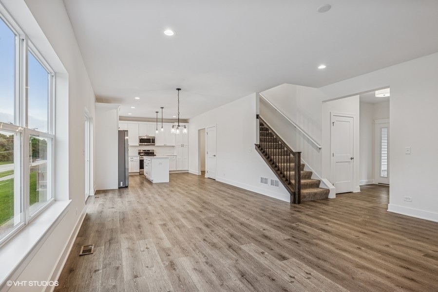 735 Fox Trail Terrace Cary, IL 60013 - Photo 6 of 21 a view of an empty room with wooden floor kitchen view and a window