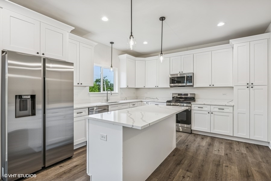 735 Fox Trail Terrace Cary, IL 60013 - Photo 7 of 21 a kitchen with kitchen island white cabinets and stainless steel appliances