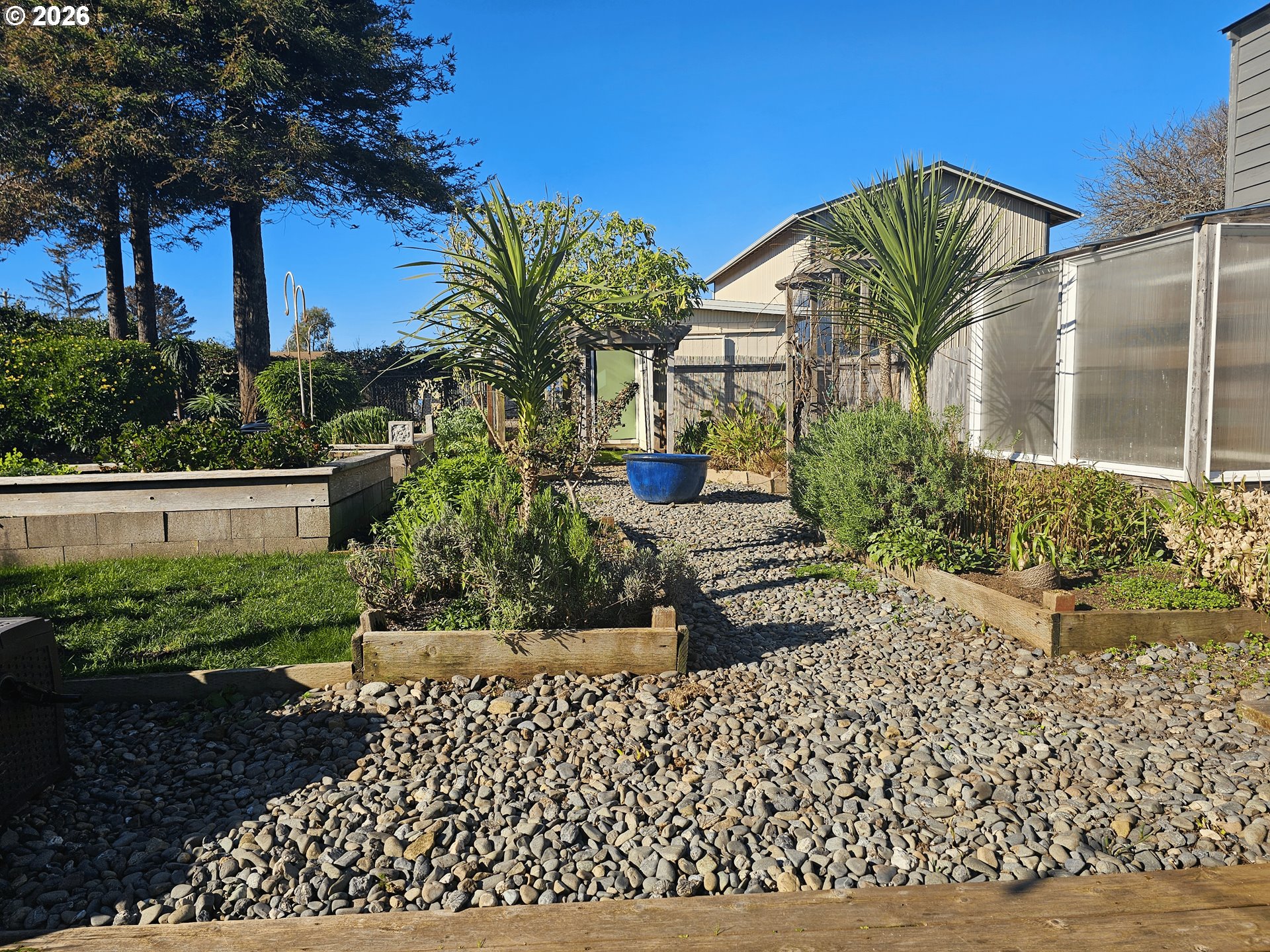 237 Wharf Street Brookings, OR 97415 - Photo 16 of 27 a view of a house with a yard and table and chair under an umbrella