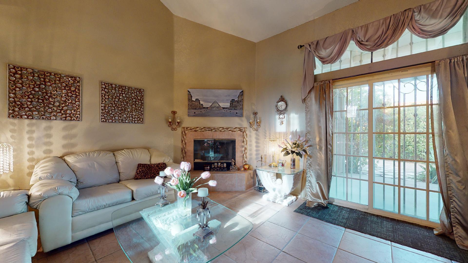 45808 Sutter Creek Road Indio, CA 92201 - Photo 15 of 55 a living room with furniture a fireplace and a floor to ceiling window