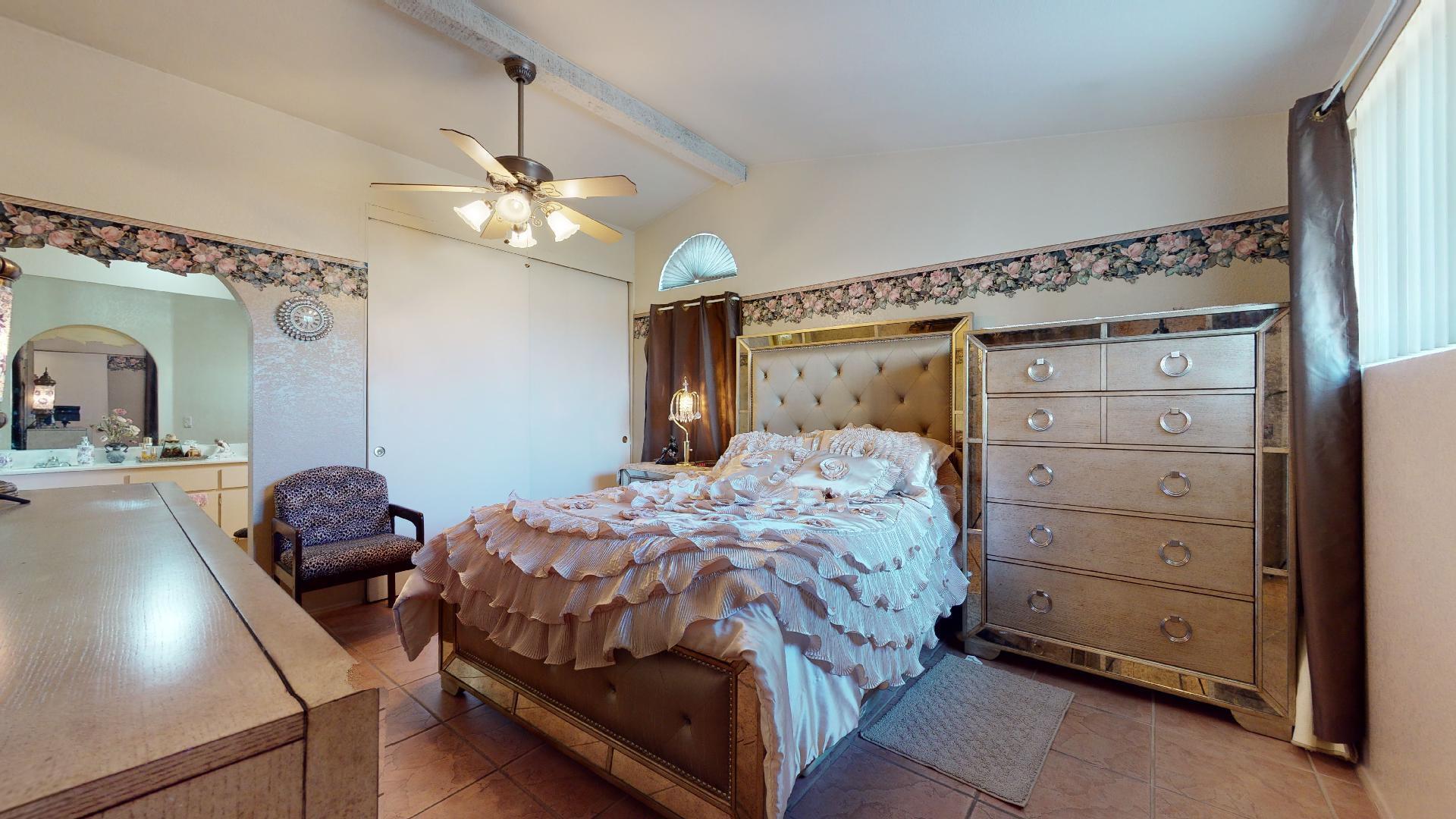 45808 Sutter Creek Road Indio, CA 92201 - Photo 22 of 55 a bedroom with a bed and a chandelier