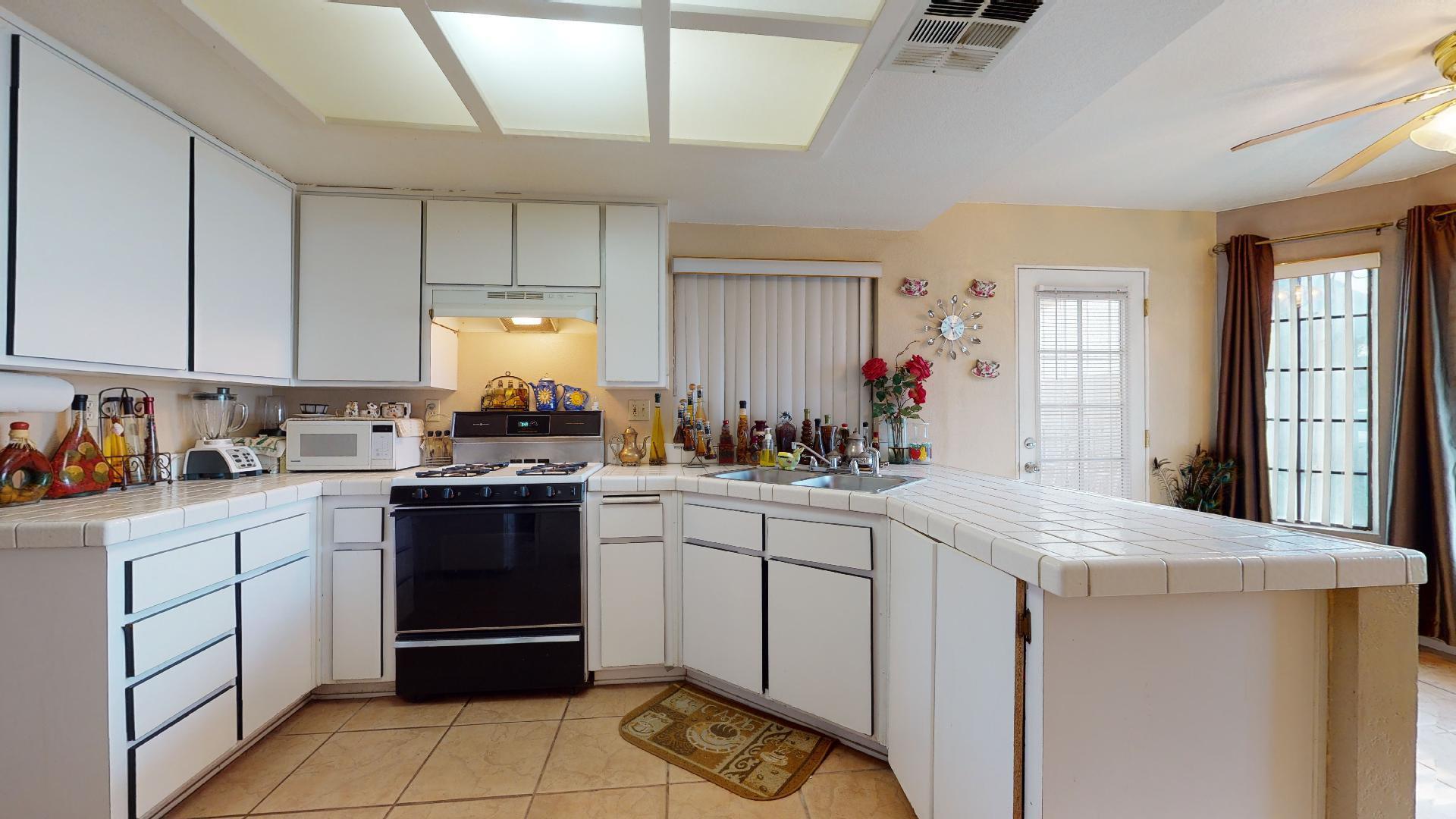 45808 Sutter Creek Road Indio, CA 92201 - Photo 5 of 55 a kitchen with granite countertop a sink stainless steel appliances and cabinets