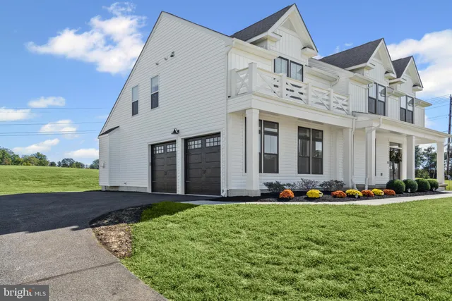 a front view of a house with a big yard and potted plants