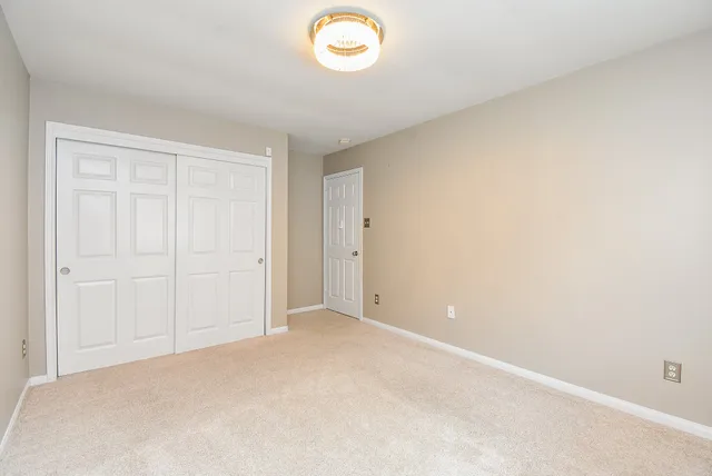 an empty room with windows and closet