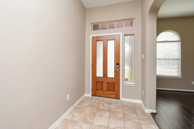 an empty room with windows closet and front door