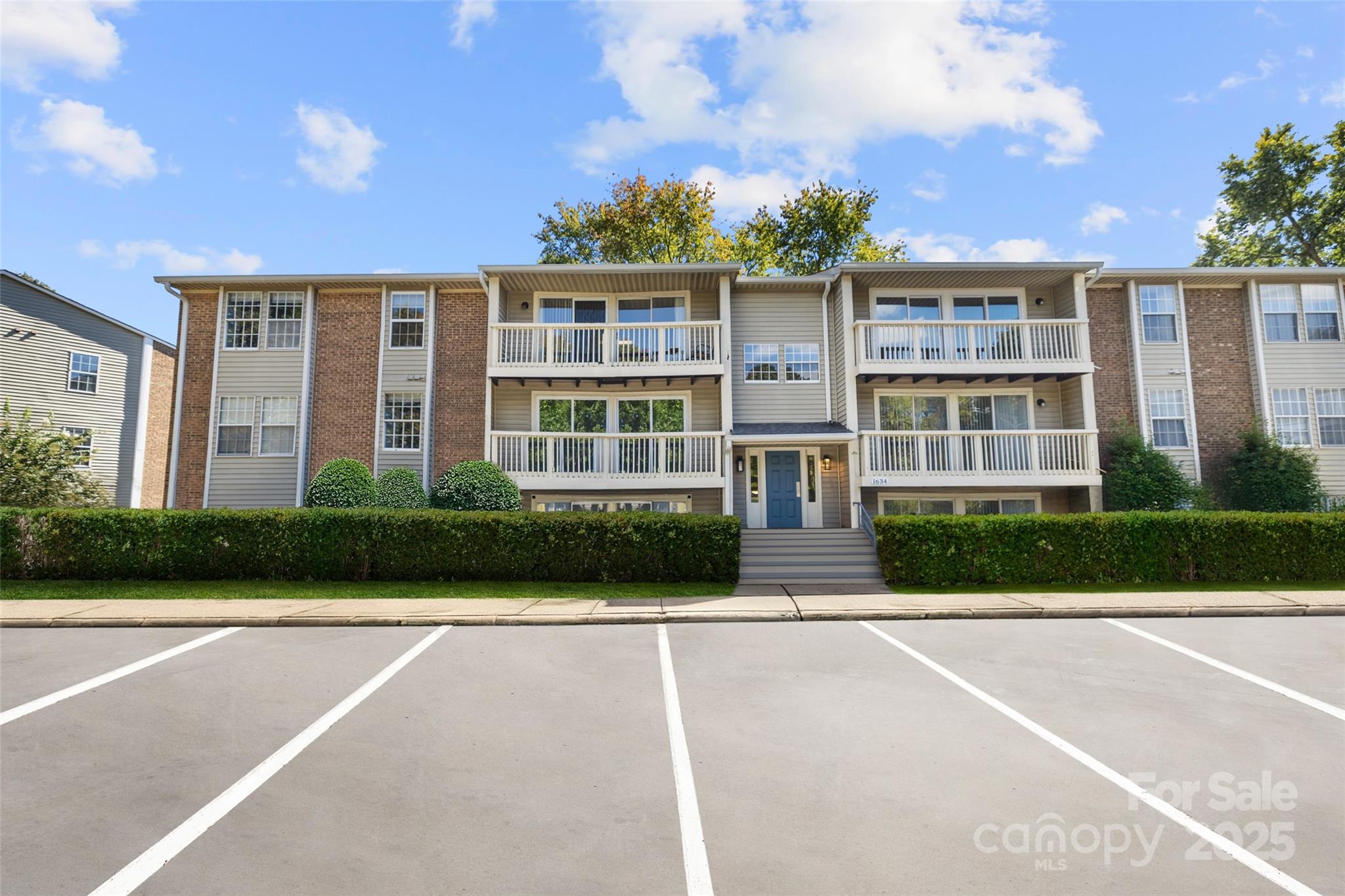 1634 Arlyn Circle, Unit J Charlotte, NC 28213 - Photo 1 of 13 a front view of a residential apartment building with a yard