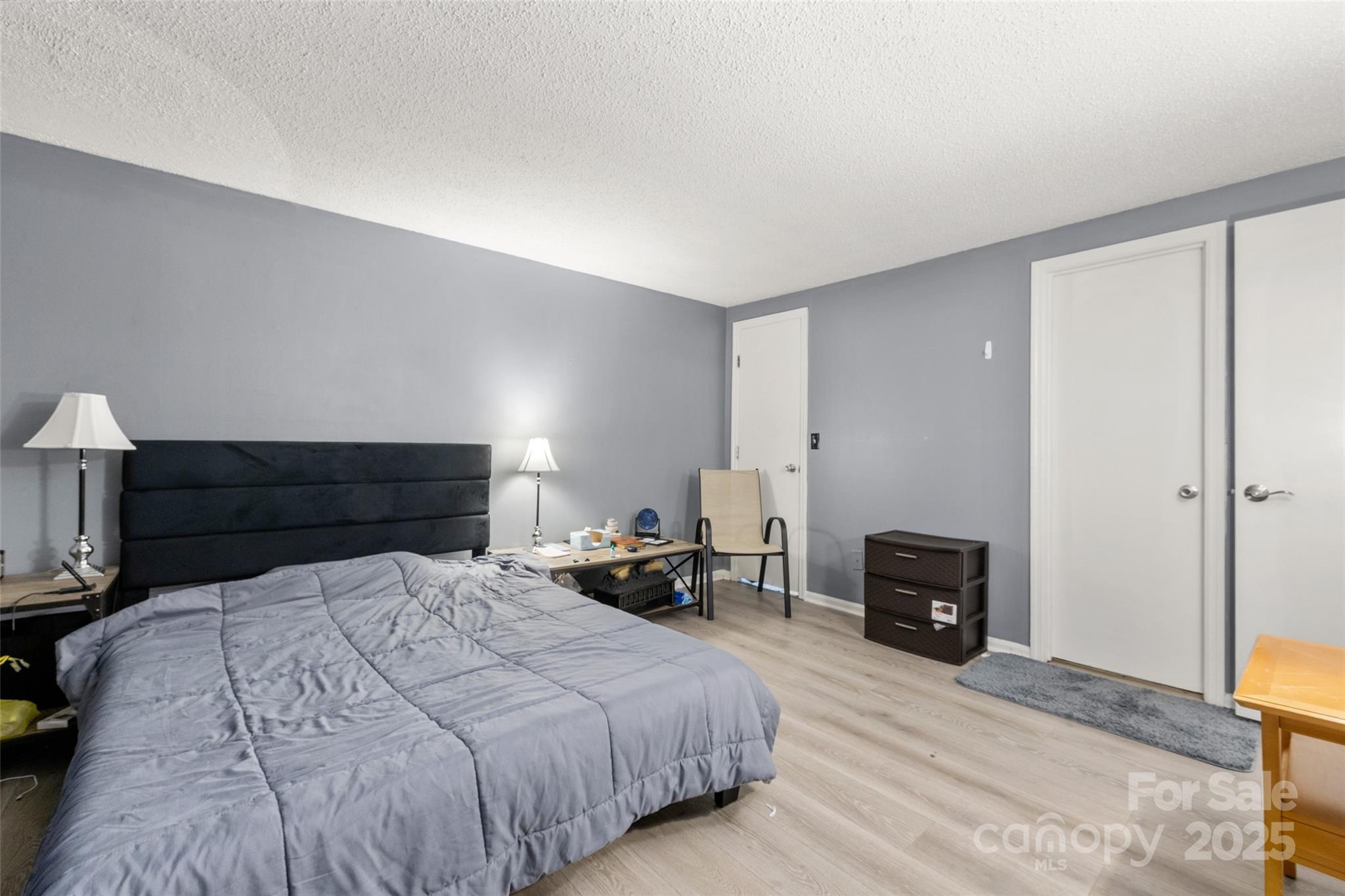 1634 Arlyn Circle, Unit J Charlotte, NC 28213 - Photo 11 of 13 a bedroom with a bed and a lamp on table