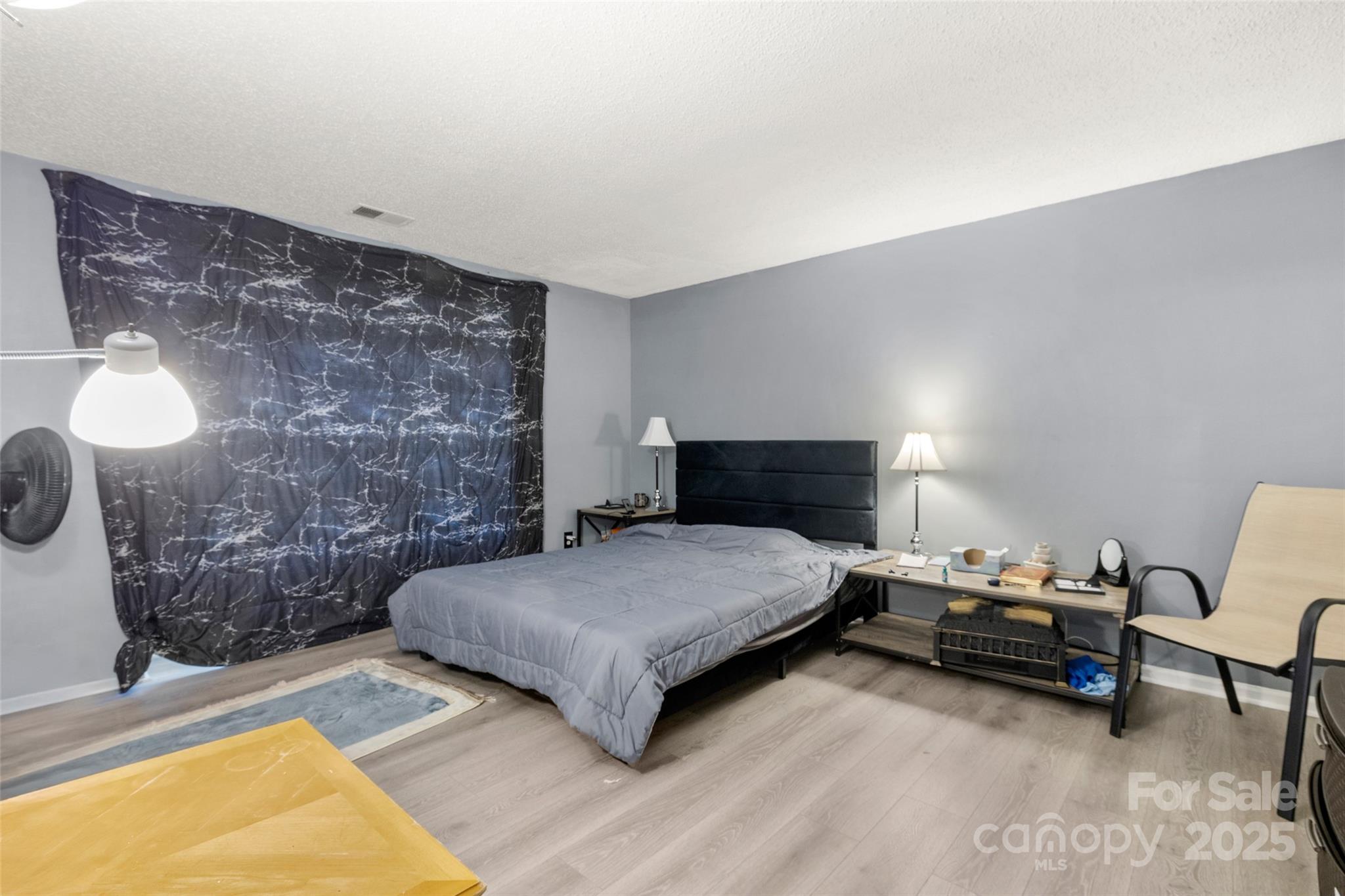 1634 Arlyn Circle, Unit J Charlotte, NC 28213 - Photo 10 of 13 a bedroom with a bed and a lamp with the potted plant