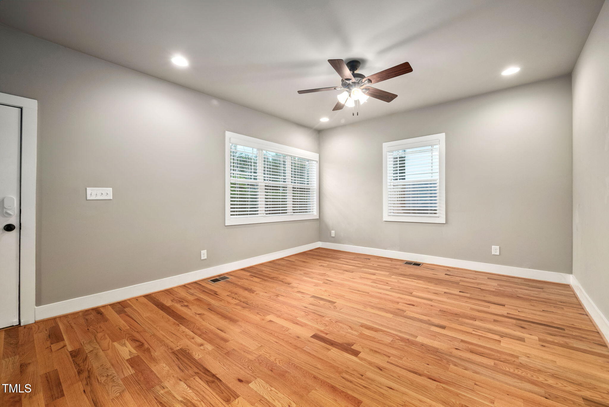 325 Martin Luther King Jr Boulevard Raleigh, NC 27601 - Photo 6 of 32 an empty room with wooden floor fan and windows