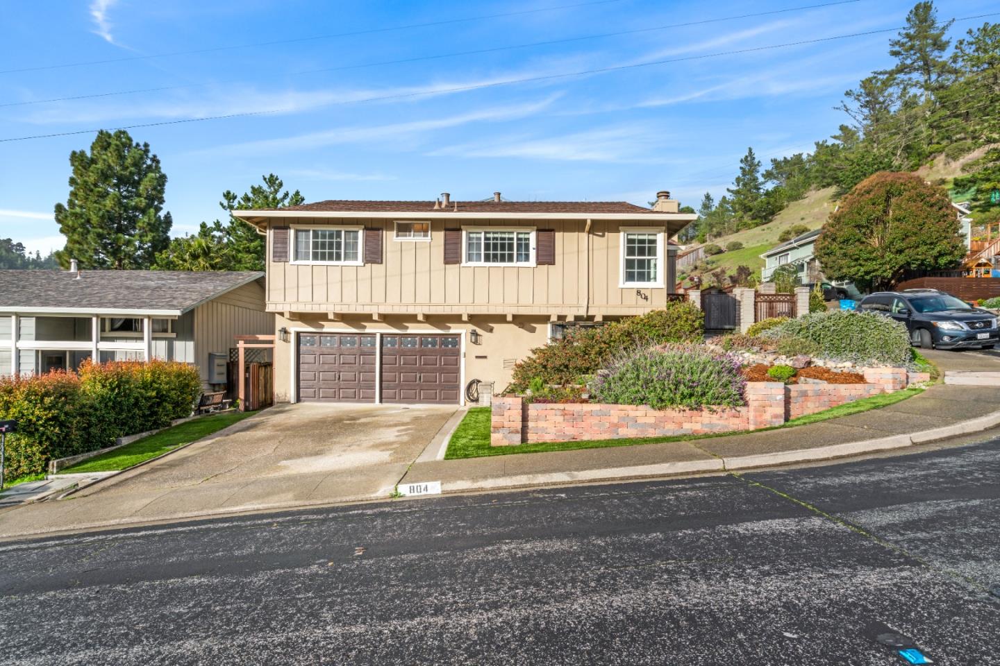 a front view of a house with a yard and potted plants